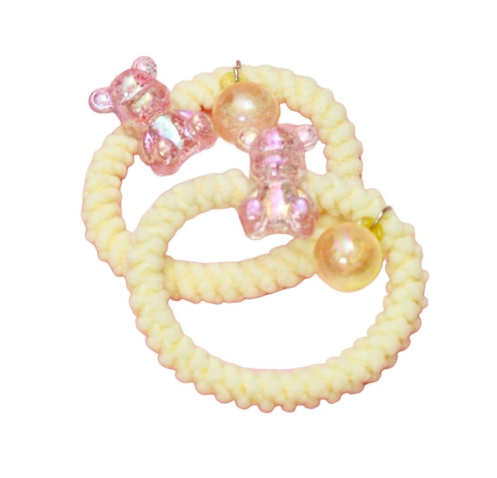 Assorted colors of Yellow Bee soft braided rubber bands with pearls and glittery charms, ready to style any hair type.