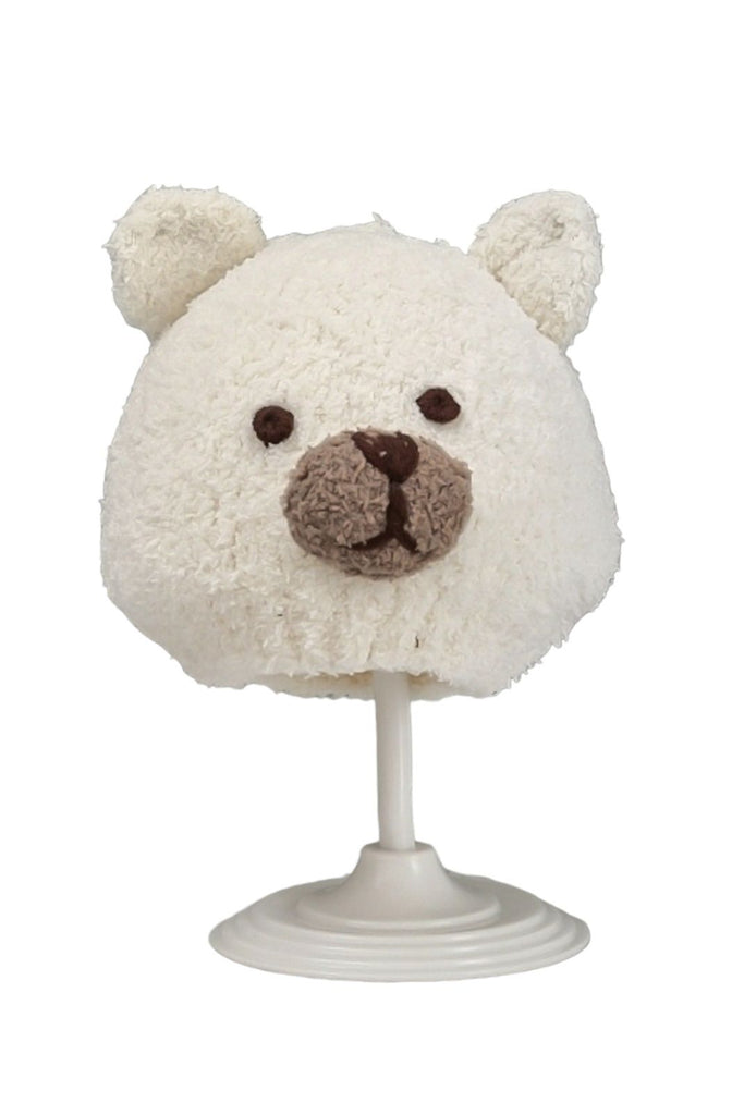 Full view of the white knitted bear beanie for toddlers, displayed on a white stand.