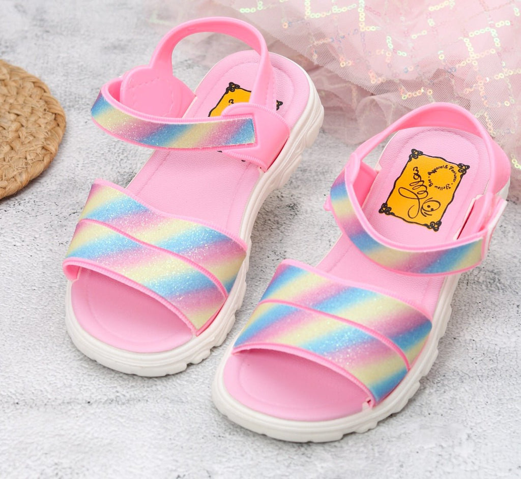 Pair of Rainbow Glitter Sandals on a textured background with a focus on the glitter straps.
