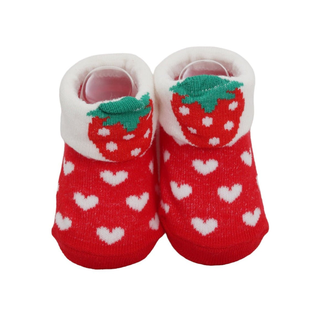 Close-up of red strawberry-themed baby socks with white hearts and green accents
