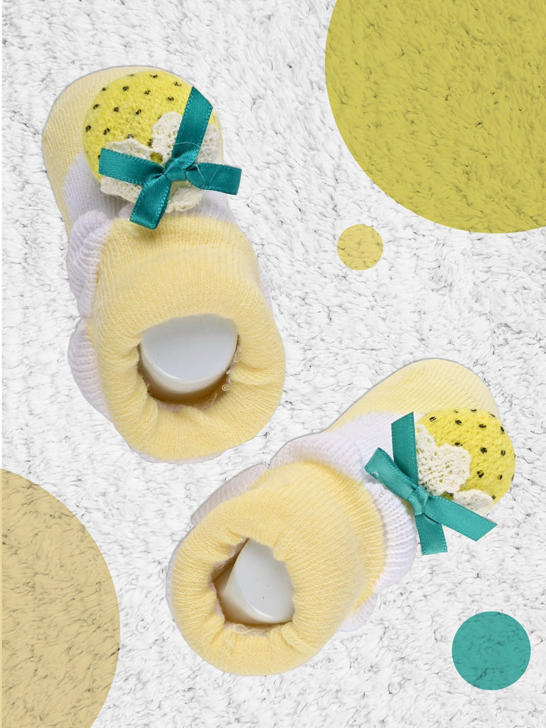 Yellow socks with strawberry embellishment and white fluff on top for toddlers