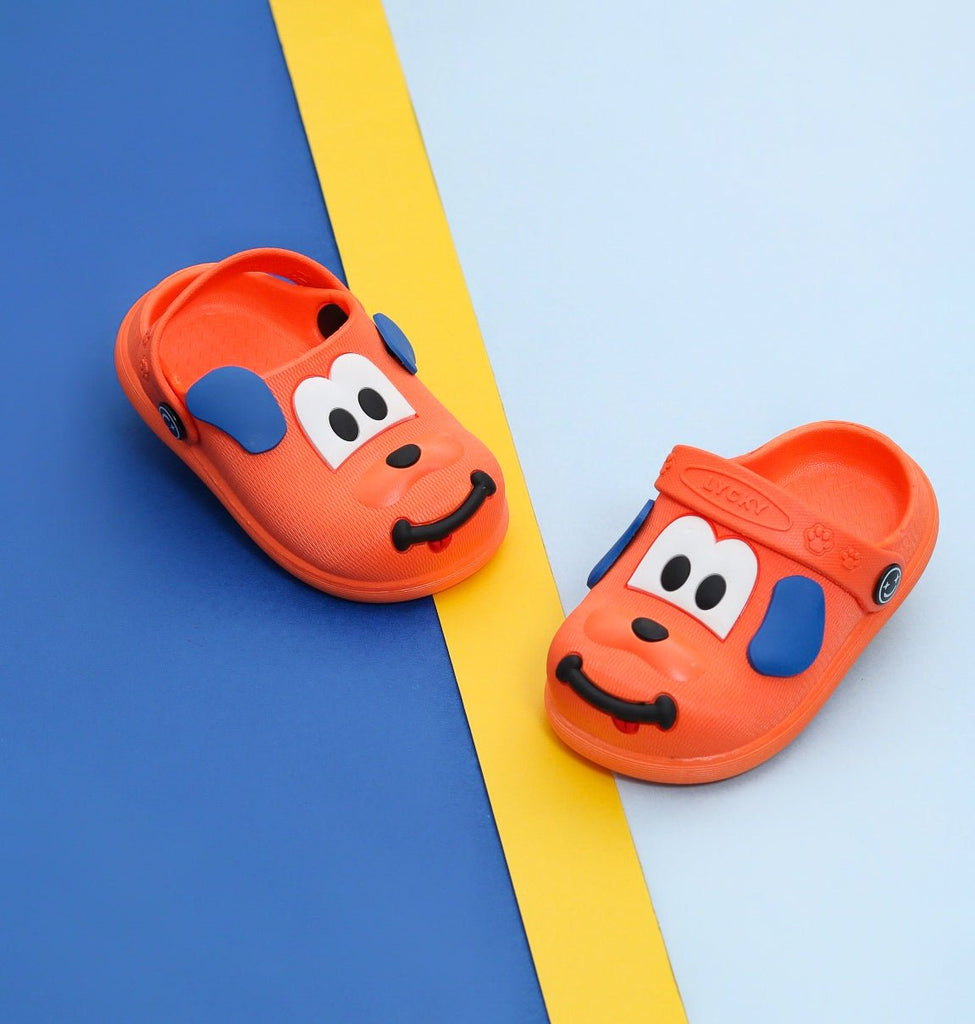 Orange boy clogs with playful puppy design on a yellow and blue background.