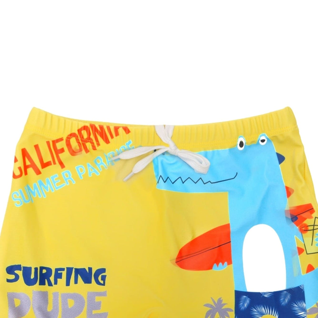 Close-up of boys' yellow swim shorts with drawstring detail and vibrant crocodile surf print, showcasing the quality and style.