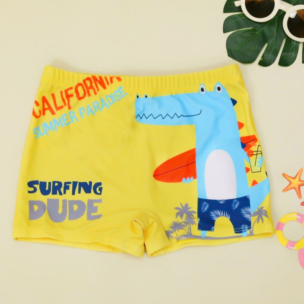 Yellow swim shorts for boys with a fun crocodile and 'California Summer Paradise' print, perfect for a day out surfing