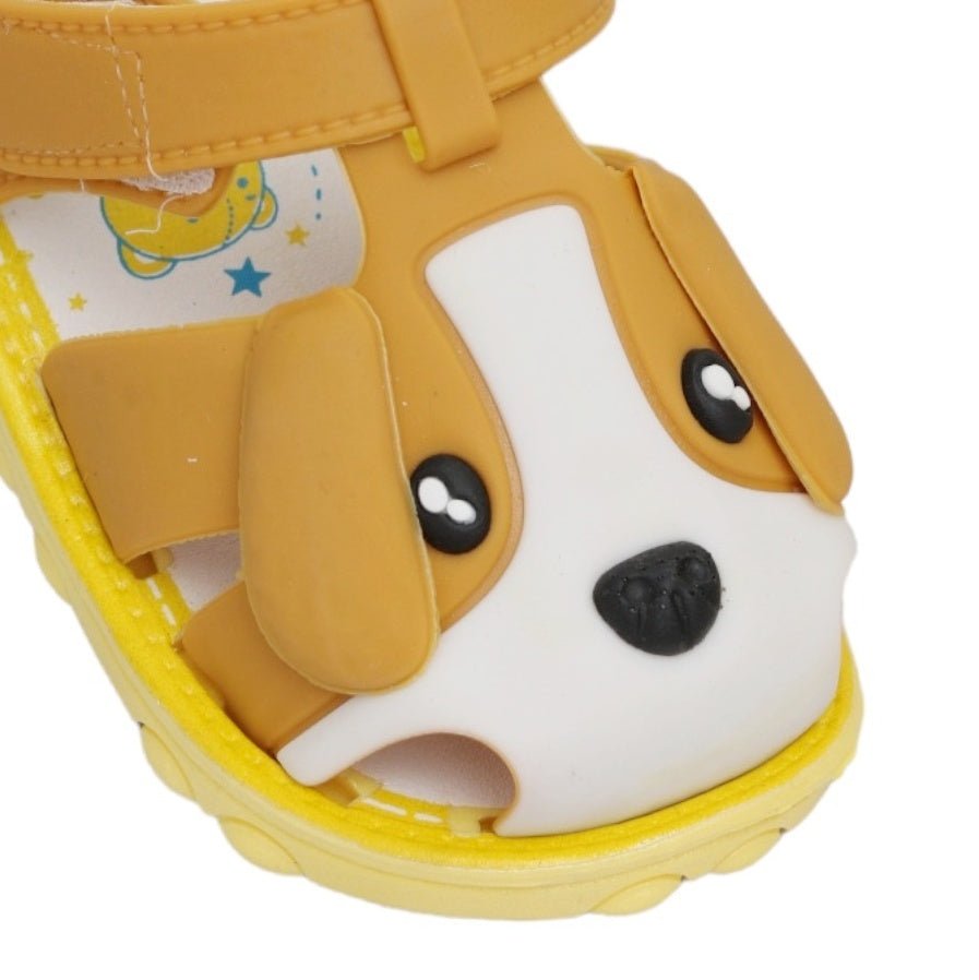 Close-up of children's brown sandals with puppy face applique and sturdy sole design..