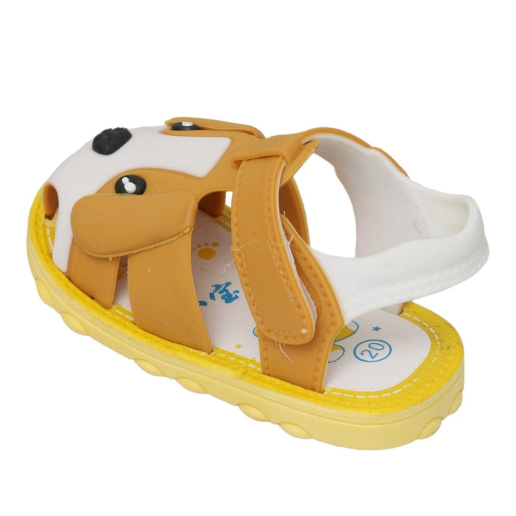 Close-up of children's brown sandals with puppy face applique and sturdy sole design.