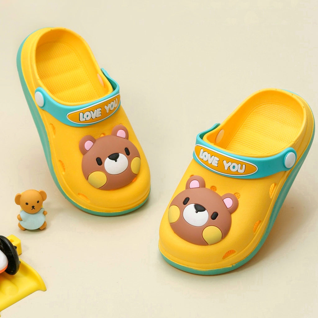 Cheerful yellow clogs with bear design and 'LOVE YOU' strap for kids on neutral background.