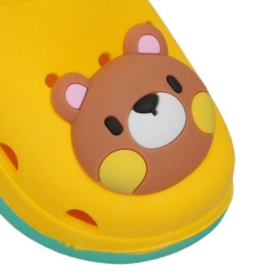 Close-up of the cute bear face on the toe of a kid's yellow clog.