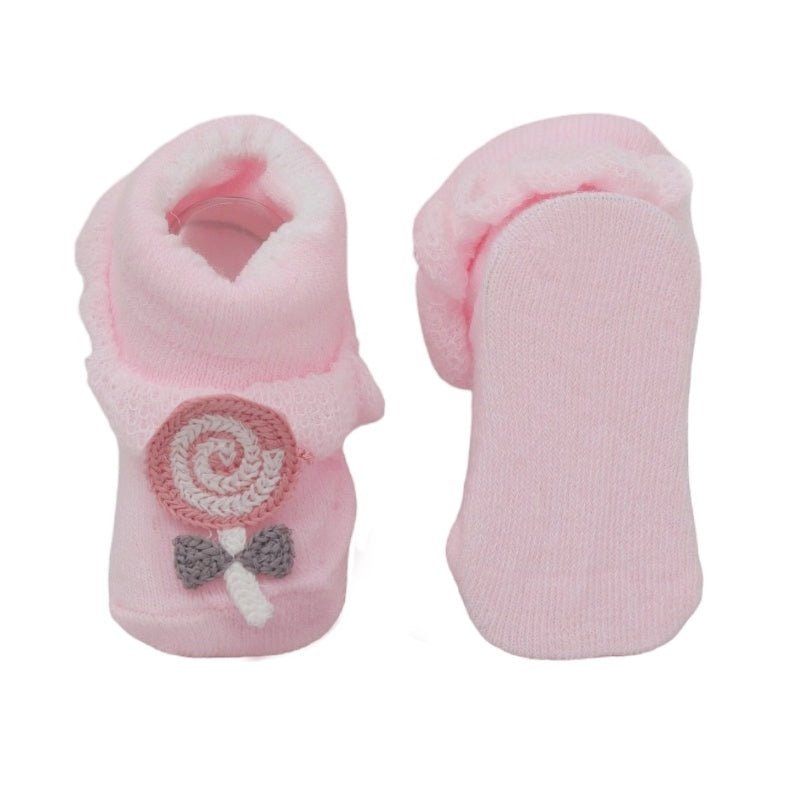 Pink baby socks with candy swirl design and bow detail, side and sole view.