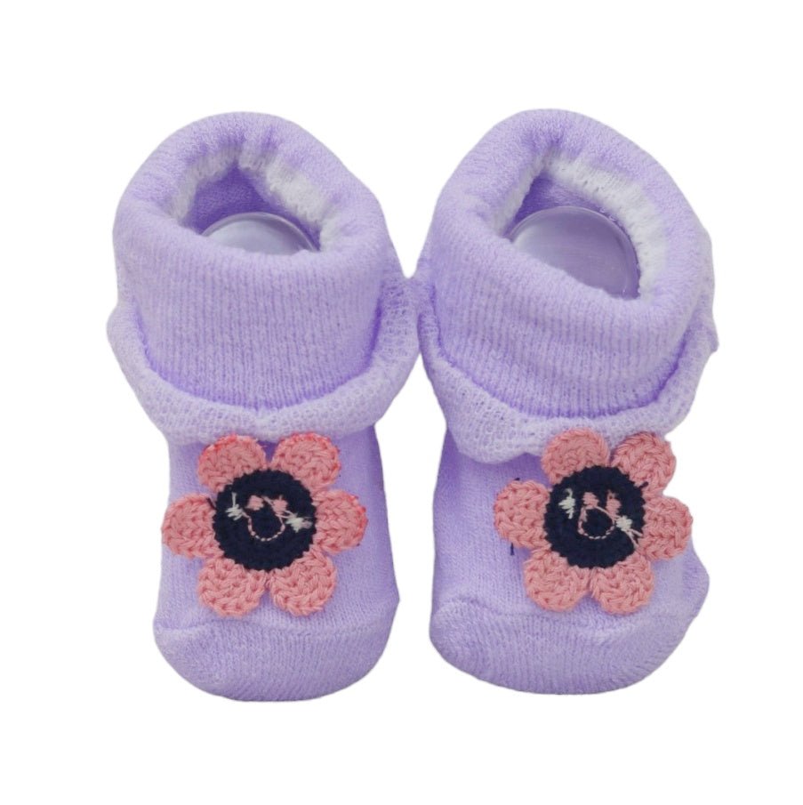 Lavender baby girl socks adorned with delicate crochet flowers on a white background.