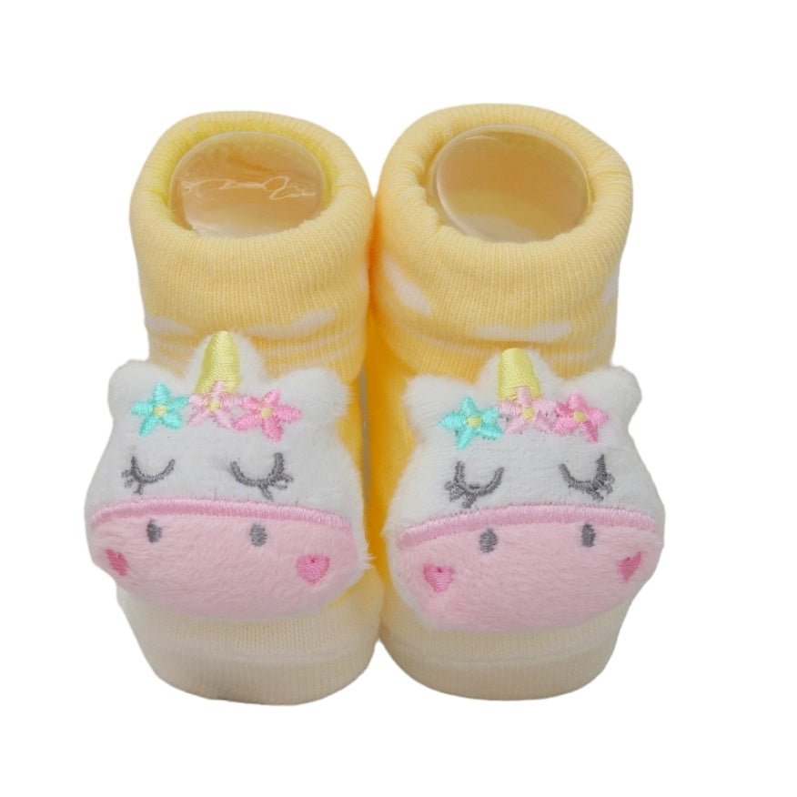 Close-up of pink teddy bear baby socks for girls on a plain background.