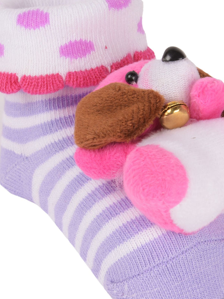 Close-up of grey teddy bear stuffed toy on top of cozy socks with breathable design details.