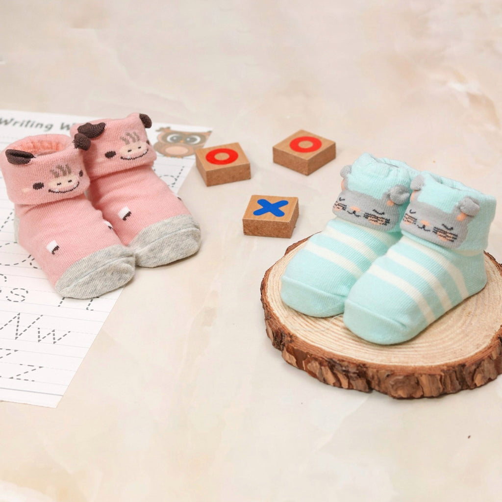 Animal-themed anti-skid socks for baby girls, displayed with educational wooden toys and a worksheet