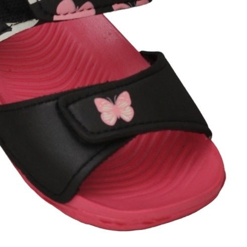 Close-up of the butterfly emblem on kids' pink and black print sandals