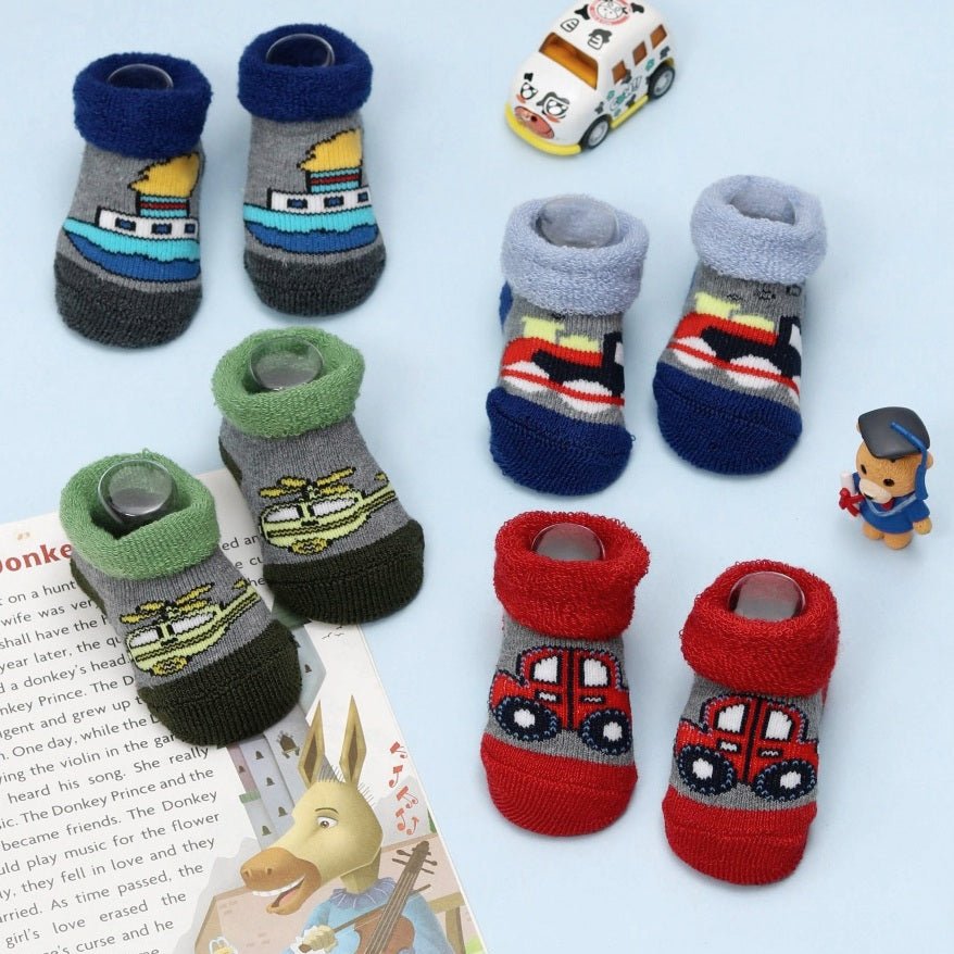 Assorted kids' transport-themed socks with various vehicle prints on a playful background.