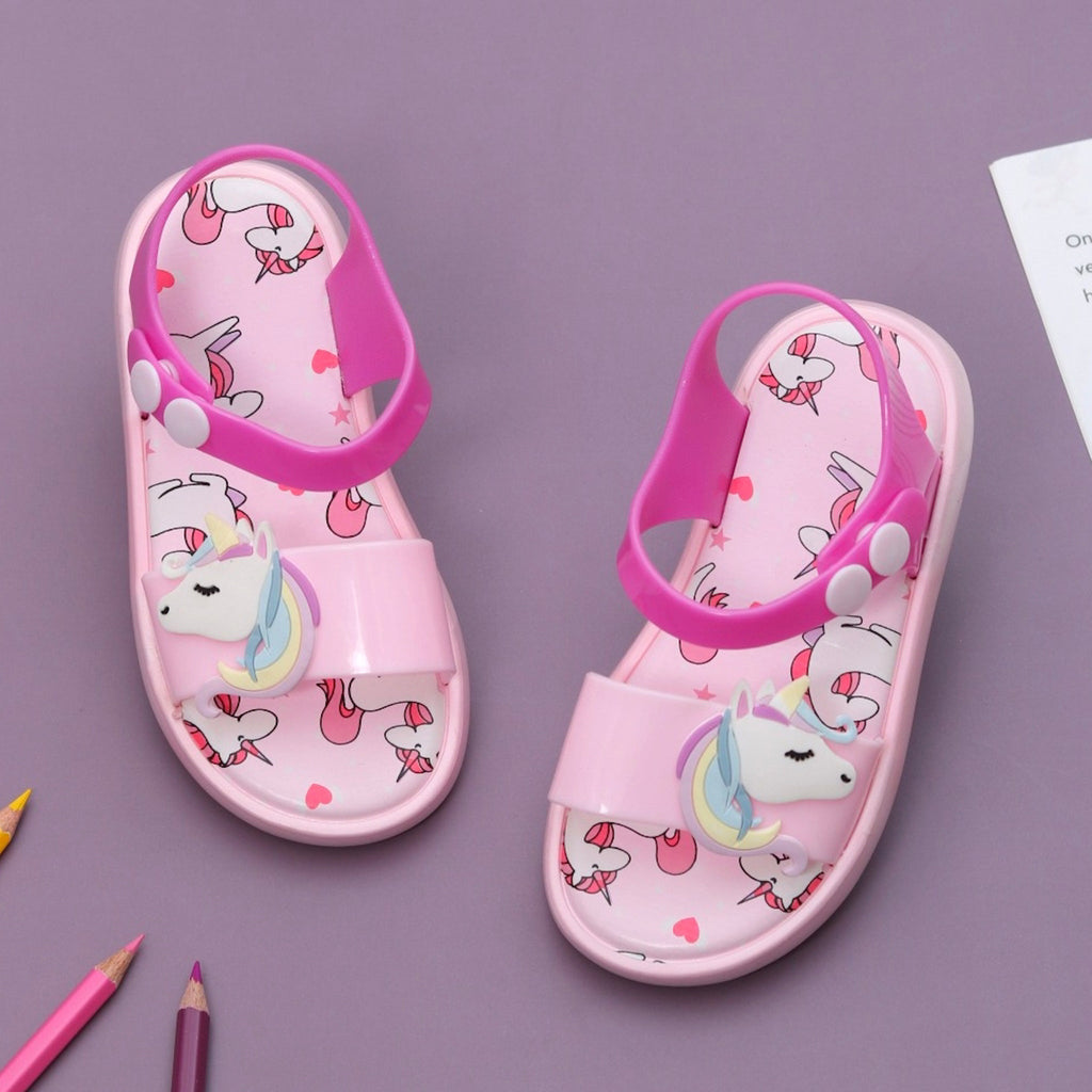 Top view of cute pink unicorn sandals for children on a purple background.