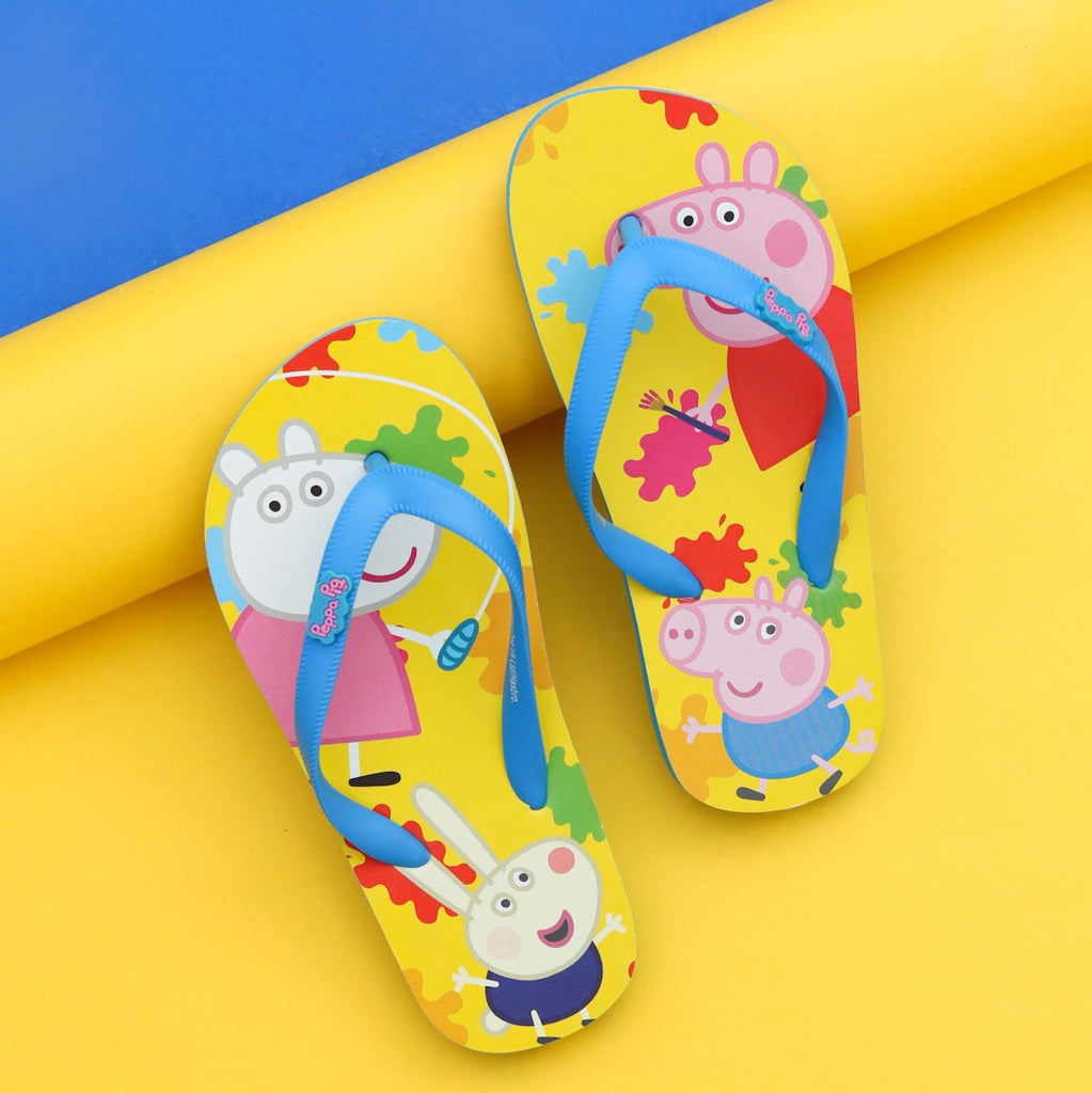 Pair of Yellow Bee George Colour Splash Flip-Flops for boys laid on a dual yellow and blue background, showcasing the playful character design and bright colors.