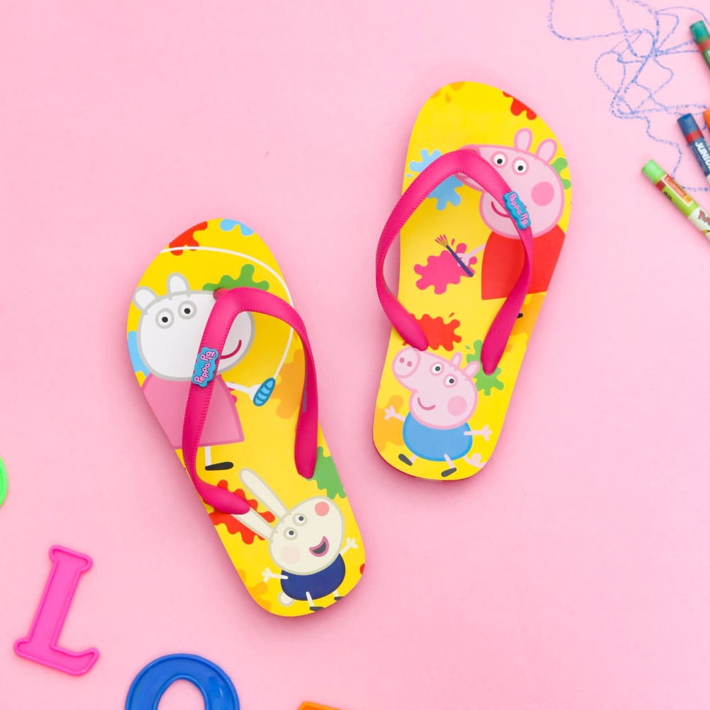 Bright yellow Peppa and George children's flip-flops with vibrant color splashes and a cheerful pink strap, showcasing a playful character.